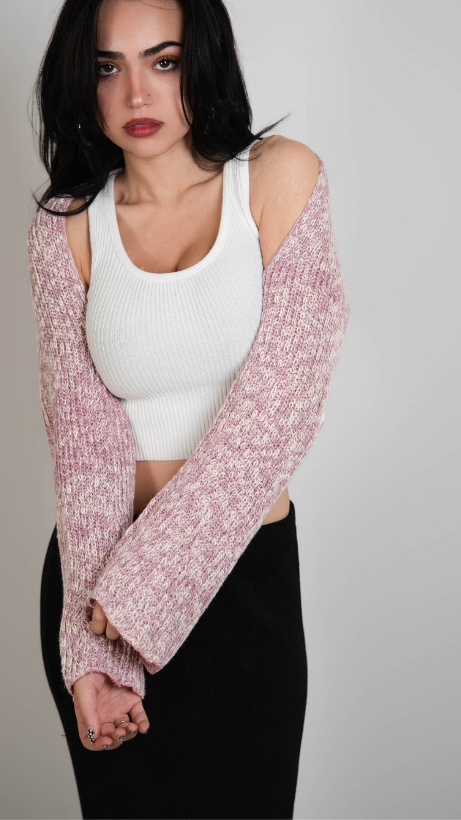 Woman wearing a pink and white mixed knit long sleeve shrug over a white scoop neck tank by The Knit House LA.