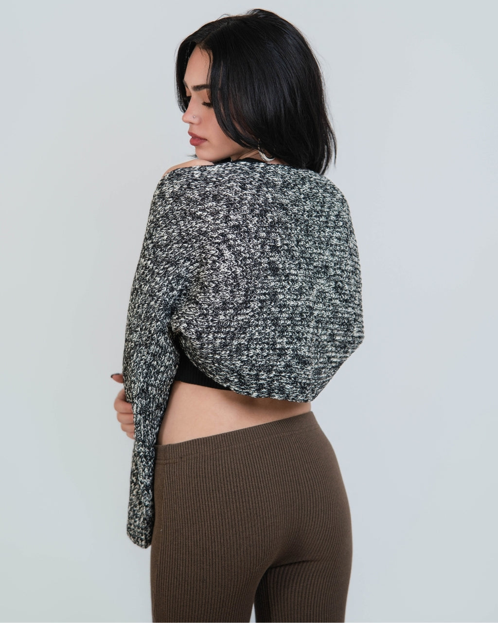 woman wearing an open long sleeve crop shrug in a black and white mixed knit by The Knit House LA.