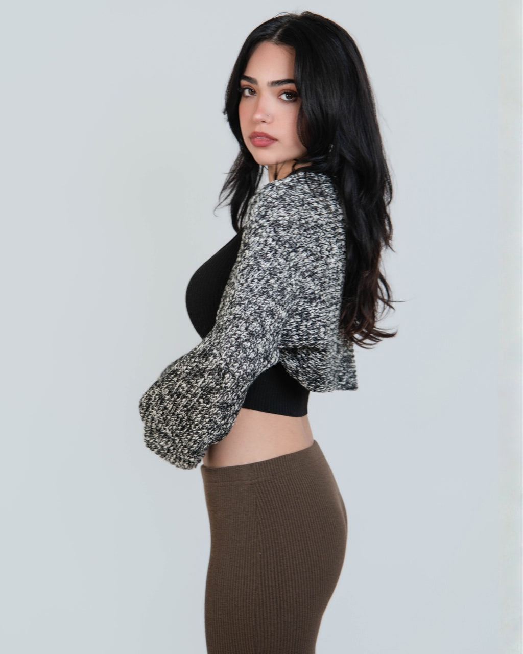 woman wearing an open long sleeve crop shrug in a black and white mixed knit by The Knit House LA.