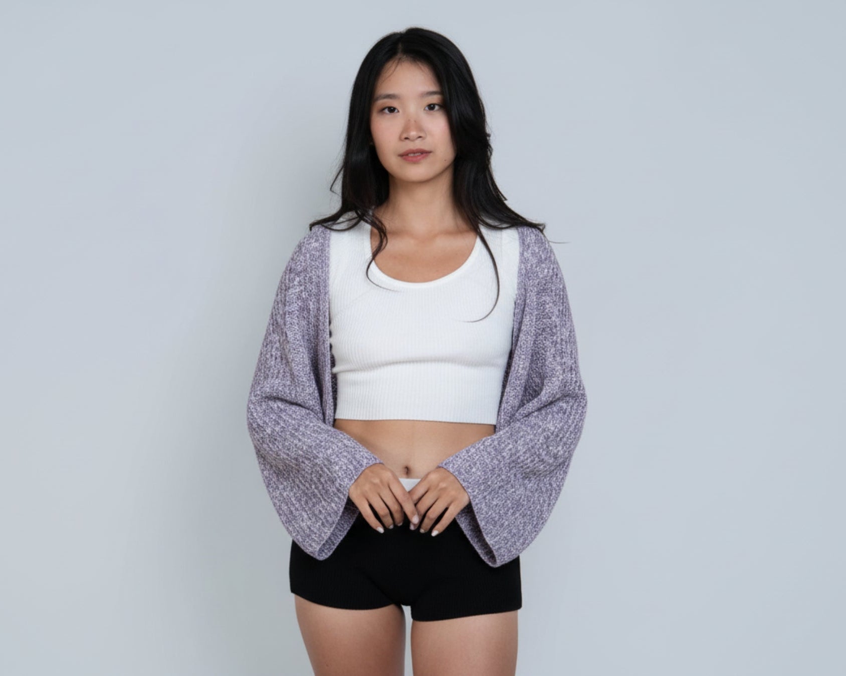 Woman wearing a long sleeve crop knit shrug in Violet purple and bone mixed knit by The Knit House LA.