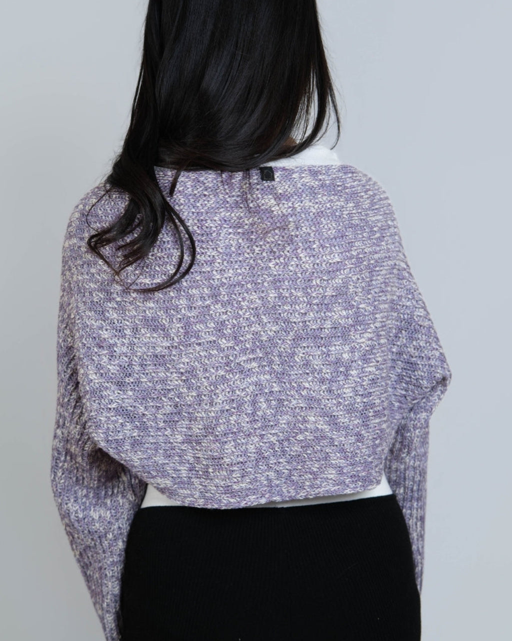 Woman wearing a long sleeve crop knit shrug in Violet purple and bone mixed knit by The Knit House LA.