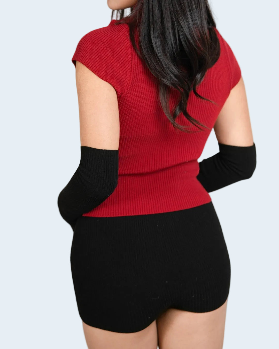 Back view of woman wearing rib knit armwarmers in Ink black by The Knit House LA.