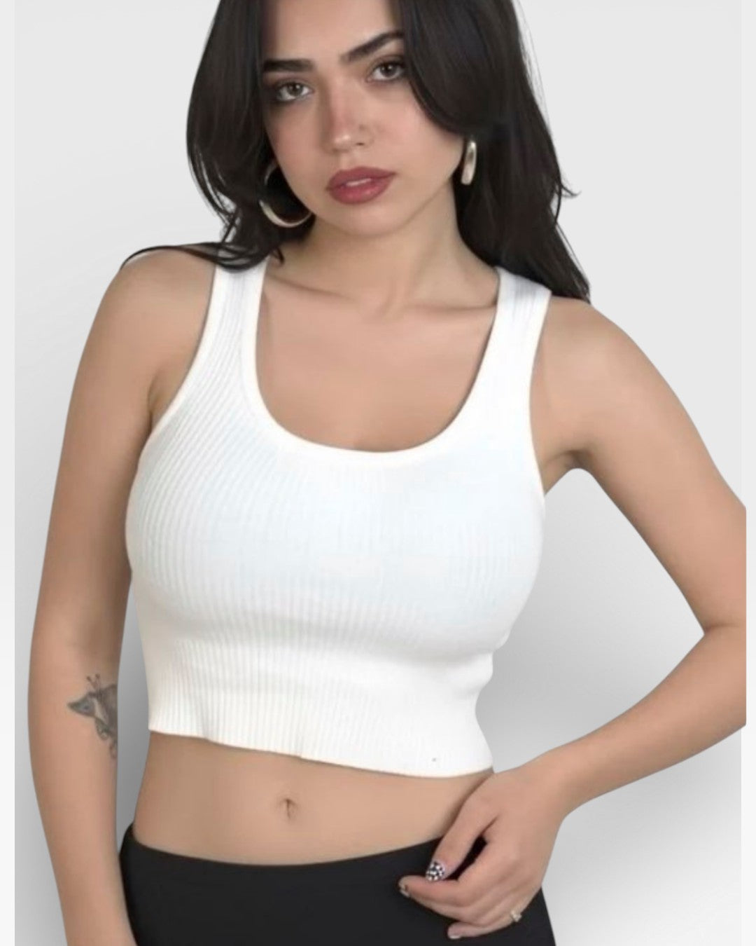 Woman wearing a Porcelain white tank top with scoop neckline by The Knit House LAagainst a plain background