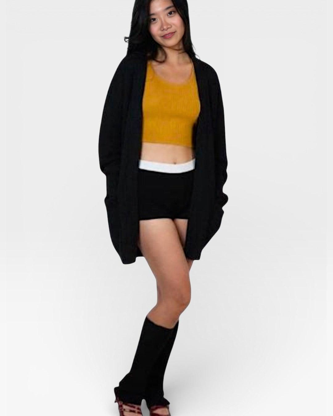 Woman wearing a mustard top, black cardigan, shorts, and rib knit legwarmers in Ink black by The Knit House LA