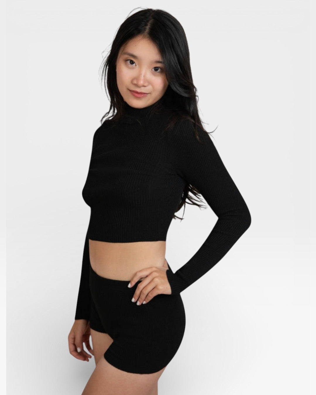 Side view of ​woman wearing fitted rib knit hot pant shorts in Ink black by The Knit House La