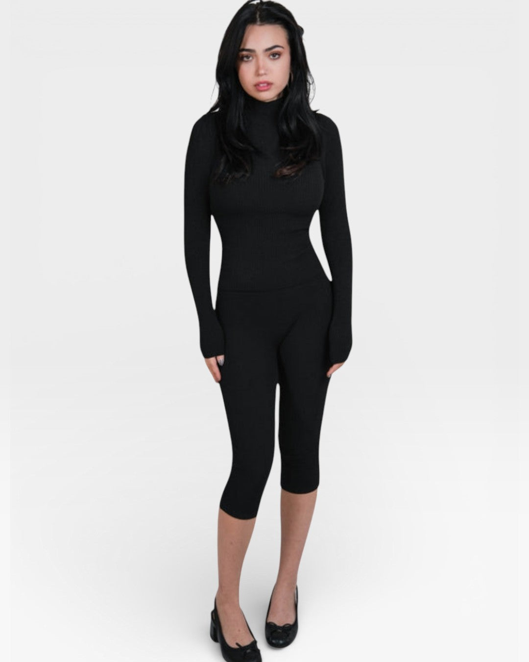 Woman wearing fitted rib knit capri pants and matching long sleeve mock neck in Ink black by The Knit House LA.