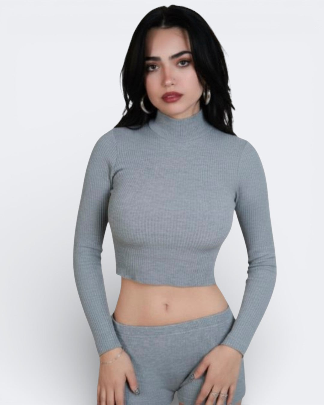 Woman wearing a gray ribbed long-sleeve top and pants on a white background