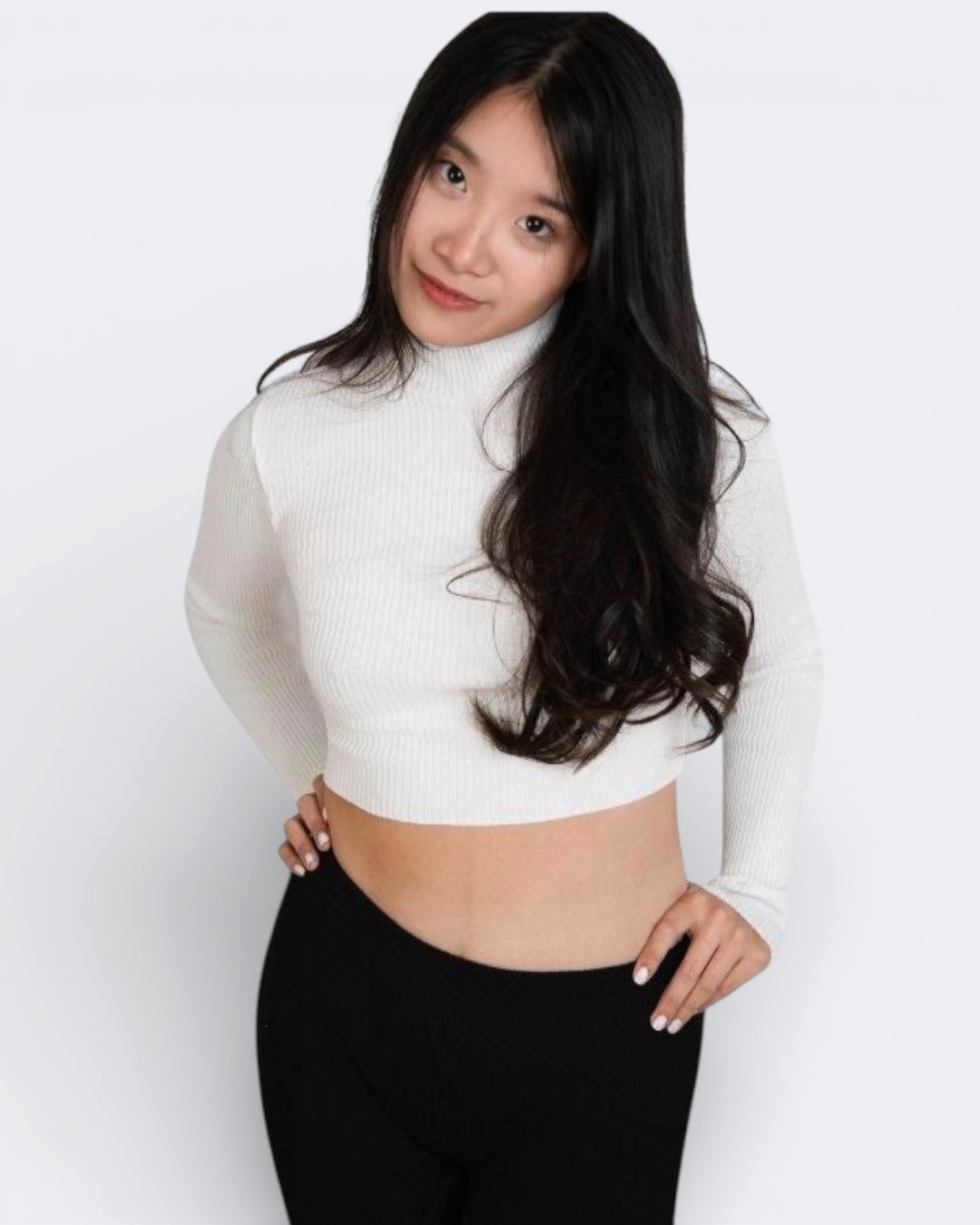 Woman wearing a fitted rib knit long sleeve crop top with high neck in Porcelain white by The Knit House LA.