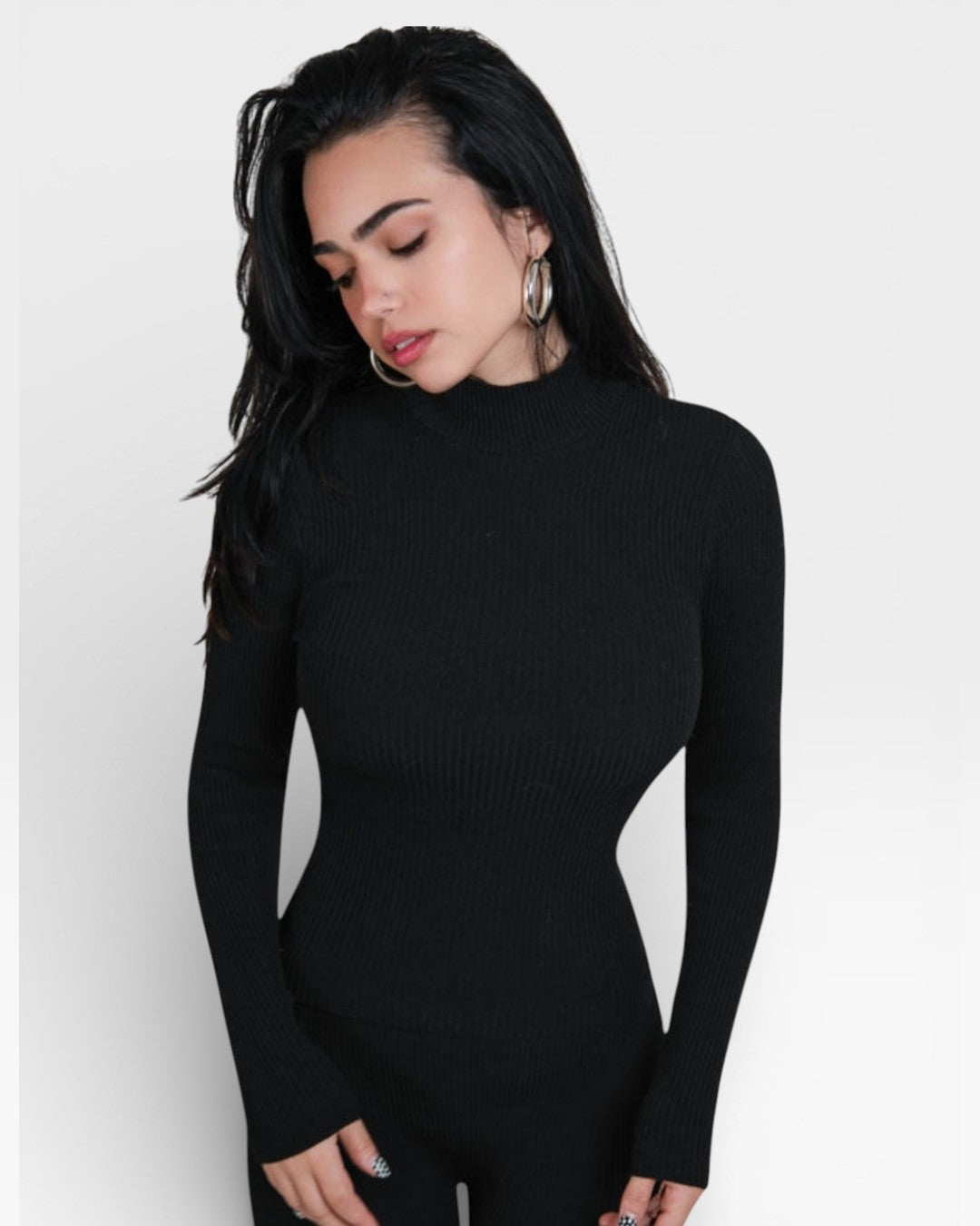 Woman wearing a black long-sleeve top against a white background