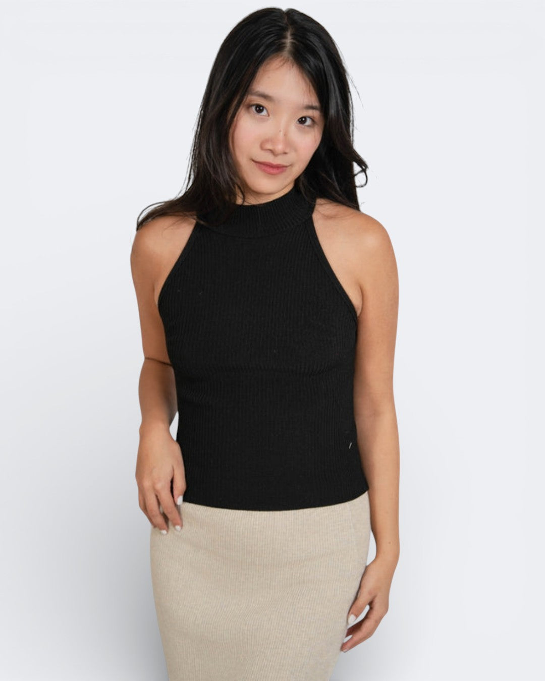Woman wearing a fitted rib knit high neck sleeveless shell in Ink black by The Knit House LA.