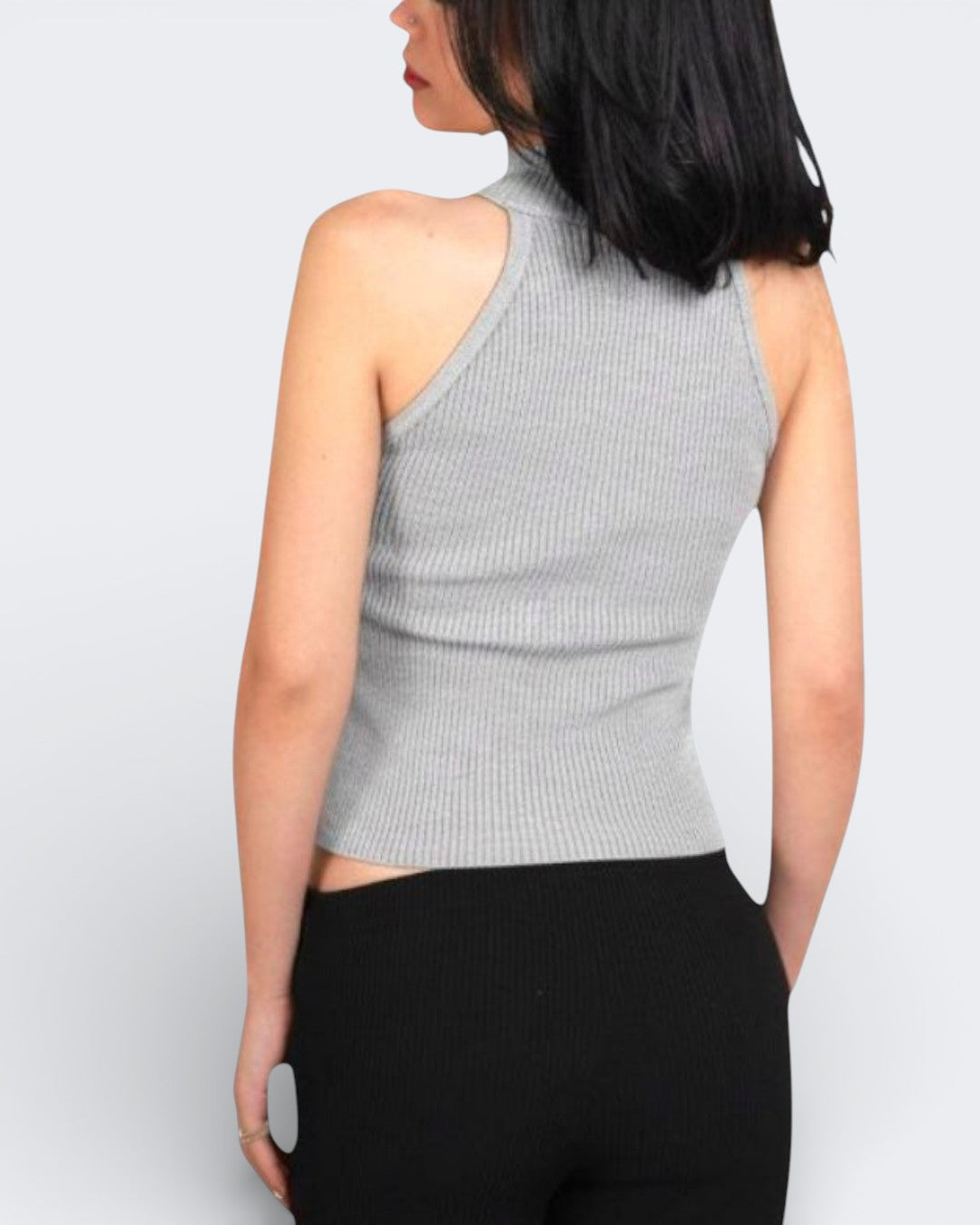 Back of woman wearing a fitted ribbed knit sleeveless shell with a high neck in Mist grey by The Knit House LA.