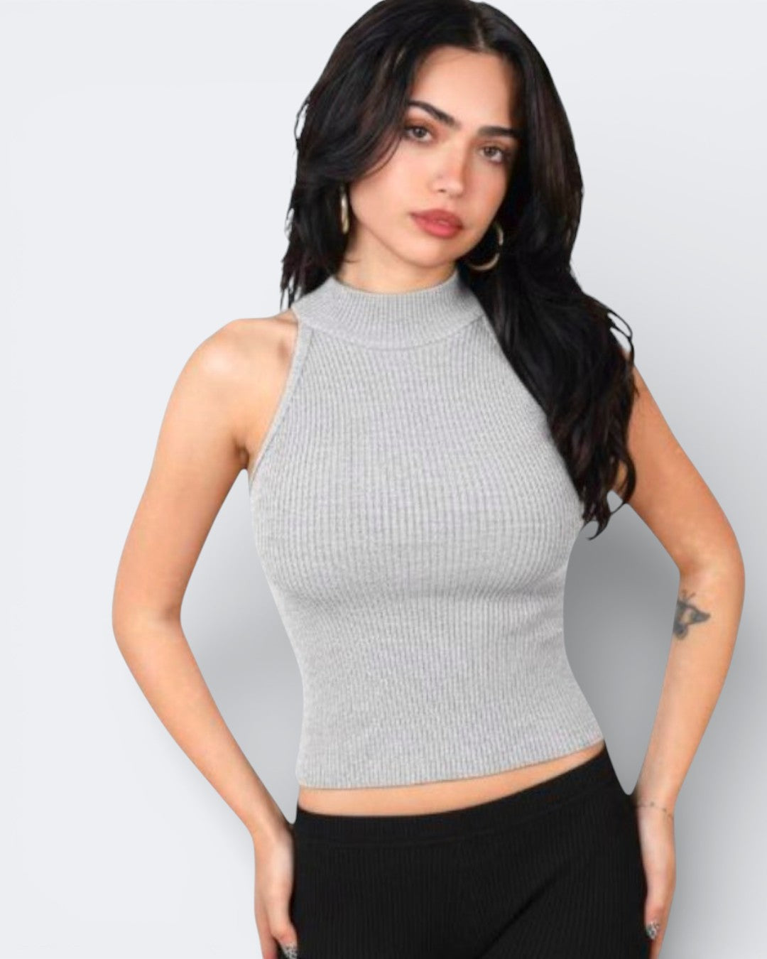 Woman wearing a fitted ribbed knit sleeveless shell with a high neck in Mist grey by The Knit House LA.