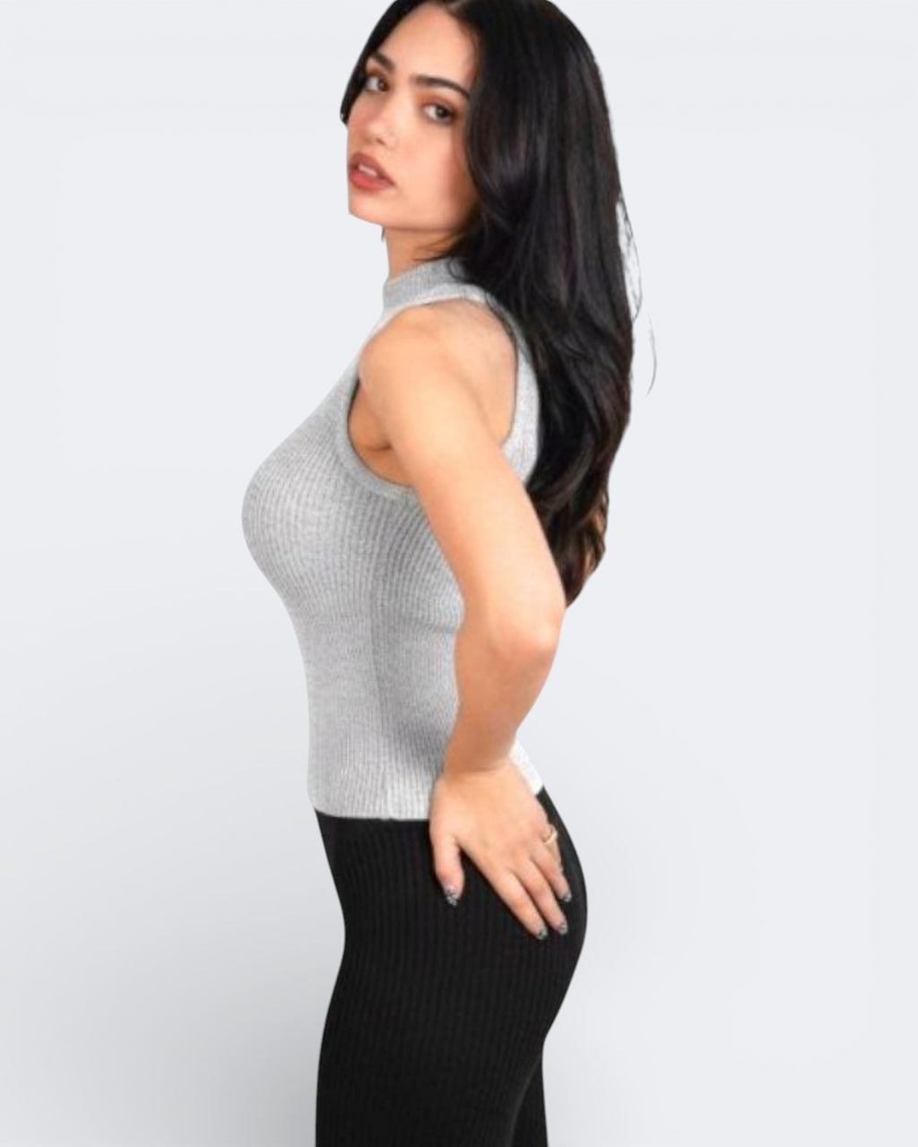 Side view of woman wearing a fitted ribbed knit sleeveless shell with a high neck in Mist grey by The Knit House LA.