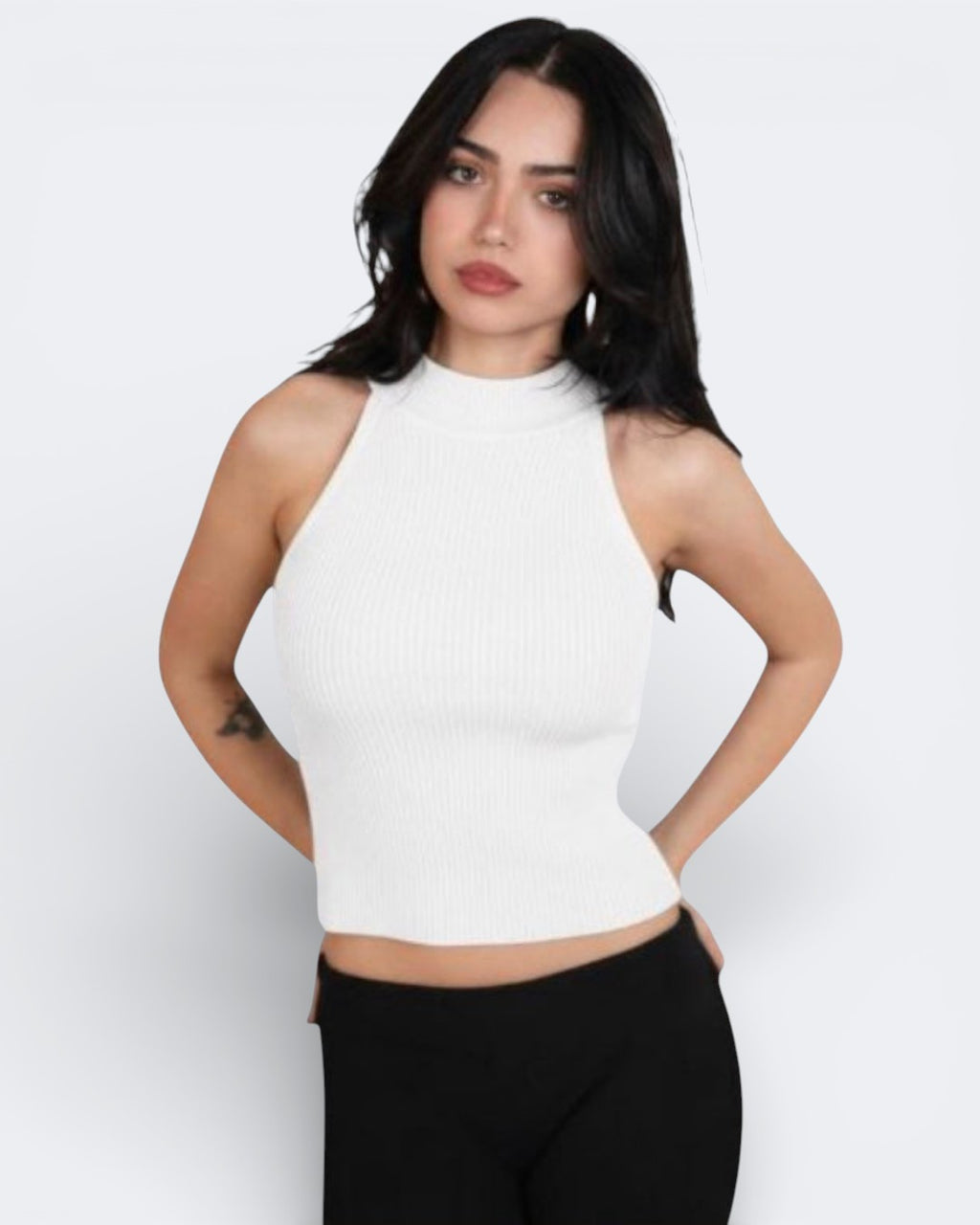 Woman wearing a fitted rib knit sleeveless shell with high neck in Porcelain white by The Knit House LA