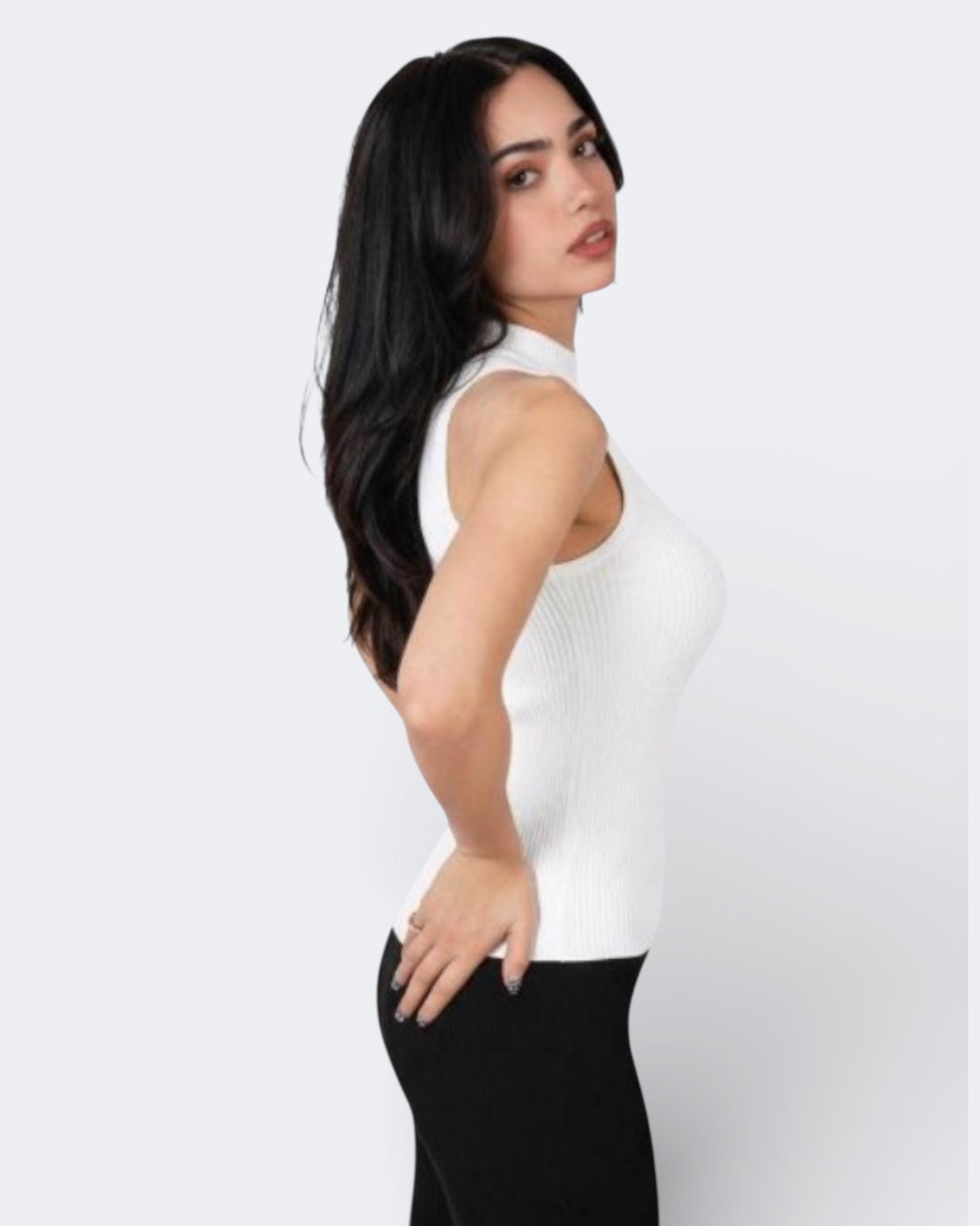 Side view of woman wearing a fitted rib knit sleeveless shell with high neck in Porcelain white by The Knit House LA