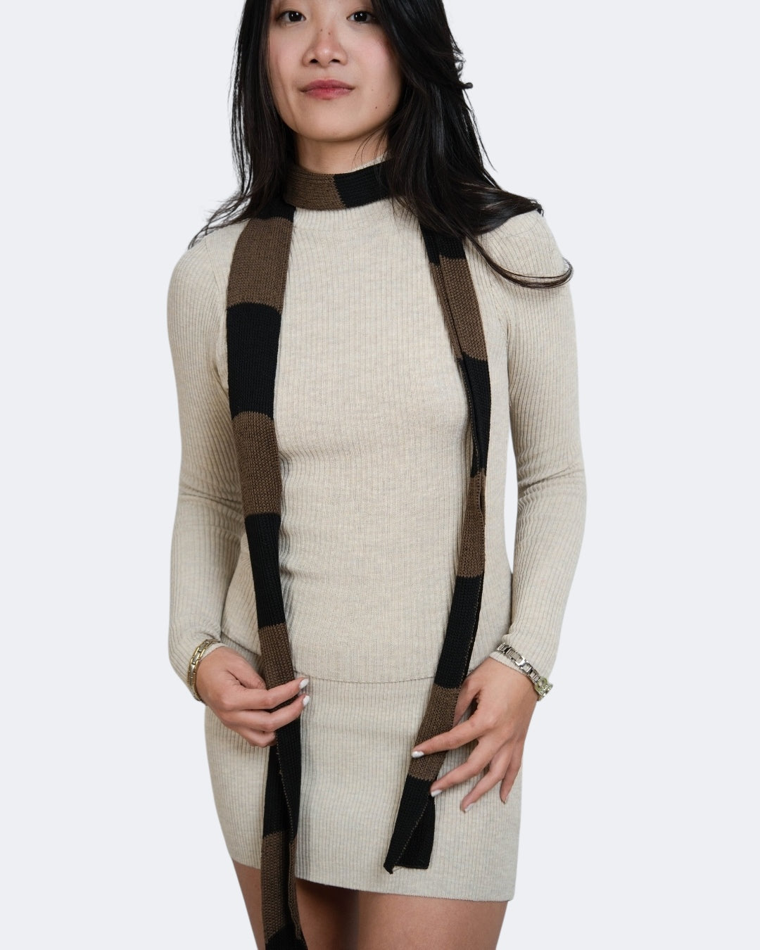Woman wearing extra long skinny knit scarf in Bark brown and Coal black by The Knit House LA.
