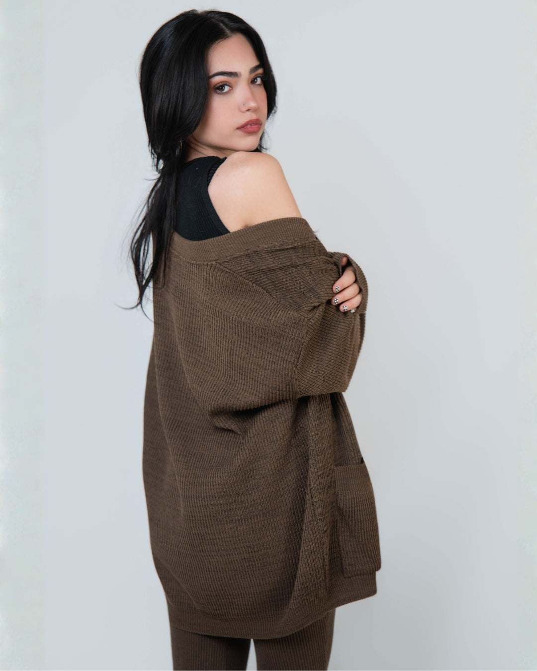 Side view of ​woman wearing relaxed rib cardigan with patch pockets in Bark brown by The Knit House LA.