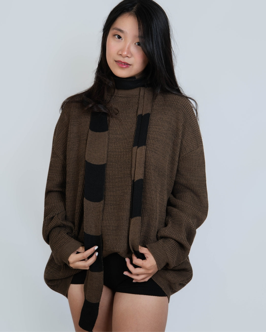 Woman wearing extra long skinny knit scarf in Bark brown and Coal black by The Knit House LA.