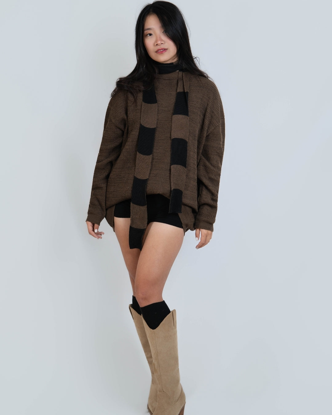 Woman wearing extra long skinny knit scarf in Bark brown and Coal black by The Knit House LA.